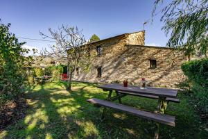 a picnic table in front of a stone building at Nogueira in Vega de Logares