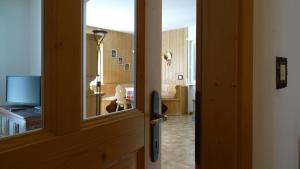 a door leading to a room with a television at La Capinera Canazei Apartments in Canazei
