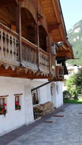 a building with a balcony on the side of it at La Capinera Canazei Apartments in Canazei