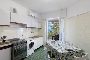 a kitchen with a table and a washing machine at Casa Alizia in Ospedaletti