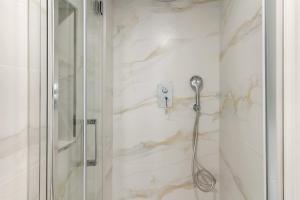a shower in a bathroom with white marble walls at Cala Luna-few steps from the beach in La Cala de Mijas +26 photos