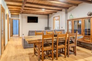 a dining room with a wooden table and chairs at Cal Manyà in Susqueda
