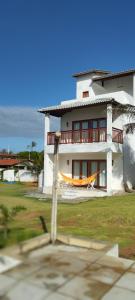 a large white house with a porch on the side of it at Casa Amarela - Guajiru in Trairi