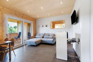 ein Wohnzimmer mit Sofa und Tisch in der Unterkunft Mettmapark - 2 Chalets in Grafenhausen
