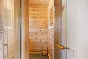 eine begehbare Dusche mit einer Holzwand in der Unterkunft Mettmapark - 2 Chalets in Grafenhausen + 37 Fotos