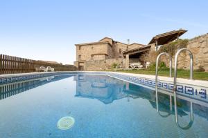 a large swimming pool in front of a building at Volta De Ferreres in Olvan