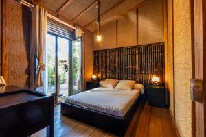 a bedroom with a bed and a large window at Chalet Bangli in Lacanau