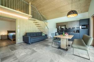 a living room with a blue couch and a table at Pixnerhof Chalet Bonita in Kastelbell-Tschars +18 photos