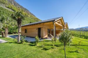 a wooden house with a mountain in the background at Pixnerhof Chalet Bonita in Kastelbell-Tschars