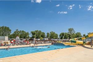 a pool at a water park with people in it at Mobilhome au Camping La Yole in Vendres