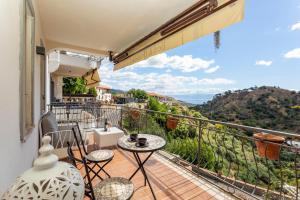 a balcony with a table and chairs and a view at Pentefur Suite Savoca in Savoca