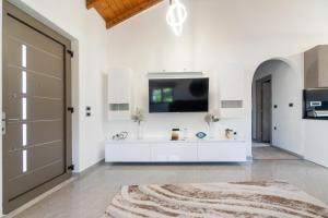 a living room with a tv and a white wall at Villa Despina in Rhodes Town