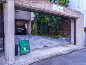 a sign in front of a building with a garage at Penthouse KOKO in Miyakonojō