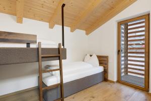 a bedroom with two bunk beds and a ladder at Rostrini Family Home Retreat in Cavalese