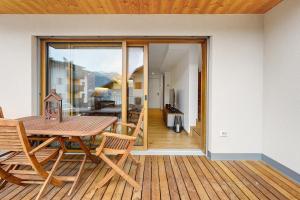 a dining room with a table and chairs on a deck at Rostrini Family Home Retreat in Cavalese