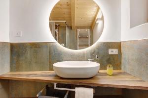 a bathroom with a white sink and a mirror at Rostrini Family Home Retreat in Cavalese +37 photos