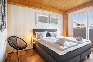 a bedroom with a large bed and a chair at Moselbude Cube mit Sauna in Traben-Trarbach