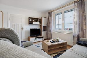 a living room with a couch and a tv at Ferienwohnung oberhalb vom Hafen 1 in Sassnitz