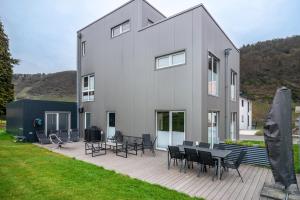 a house with chairs and tables on a deck at Moselbude Cube mit Sauna in Traben-Trarbach