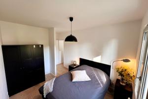 a bedroom with a bed and a black cabinet at Maison Libourne 2 Chambres in Libourne