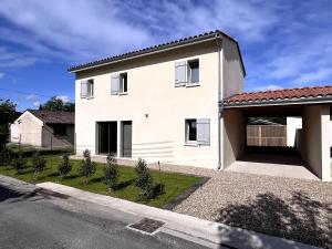 a white house with a garage at Maison Libourne 2 Chambres in Libourne