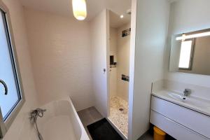 a white bathroom with a tub and a sink at Maison Libourne 2 Chambres in Libourne +36 photos