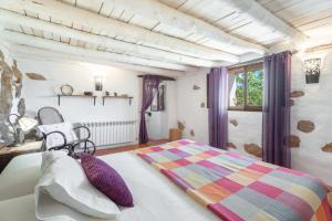 a bedroom with a bed with purple curtains and a window at El Cup in La Torre d'En Besora
