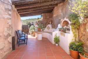 a patio with a table and chairs in a stone wall at El Cup in La Torre d'En Besora