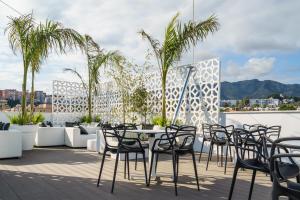 a patio with chairs and a table on a roof at Costa del Sol Torremolinos Hotel in Torremolinos