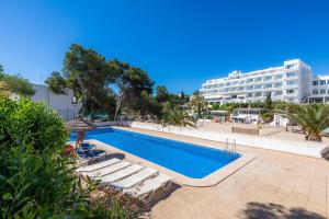 a swimming pool with lounge chairs and a hotel at Beach Apartment 11 in Cala d´Or