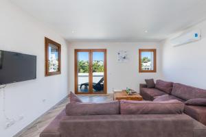 a living room with a couch and a flat screen tv at Beach Apartment 11 in Cala d´Or