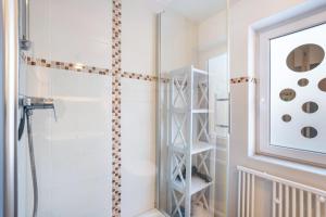 a bathroom with a shower with a glass door at Ferienwohnung Reinfeld in Hohwacht +16 photos