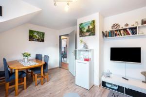 a kitchen and dining room with a table and a refrigerator at Ferienwohnung Reinfeld in Hohwacht