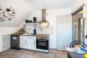 a kitchen with white cabinets and a stove top oven at Ferienwohnung Reinfeld in Hohwacht