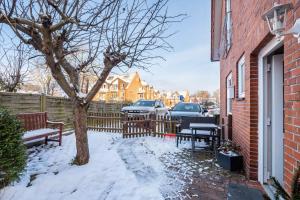 a yard with two benches and a tree in the snow at Ferienwohnung Reinfeld in Hohwacht