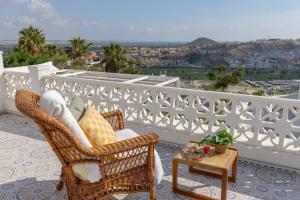 a wicker chair and a table on a balcony at Fidalsa Golf Beach in Ciudad Quesada
