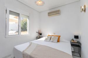 a white bedroom with a bed and a window at Fidalsa Golf Beach in Ciudad Quesada +29 photos
