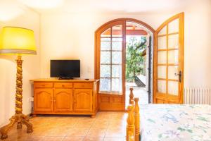 a bedroom with a bed and a television on a dresser at Ca la Irene II in Begur