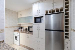 a kitchen with white cabinets and a stainless steel refrigerator at Fidalsa Bay View Romance in Guardamar del Segura