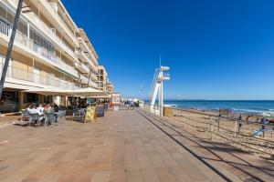 a boardwalk on the beach with people sitting at tables at Fidalsa Bay View Romance in Guardamar del Segura