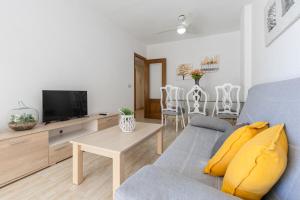a living room with a blue couch and a tv at Fidalsa Bay View Romance in Guardamar del Segura