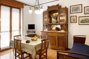 a dining room with a table and chairs and a television at Appartamento Glicine in Cisterna dʼAsti