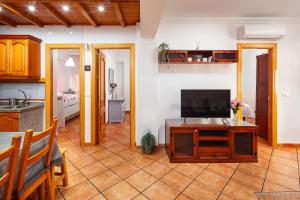 a living room with a television and a kitchen at Torre Playa in Torre del Mar