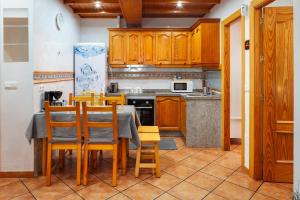 a kitchen with wooden cabinets and a table and chairs at Torre Playa in Torre del Mar