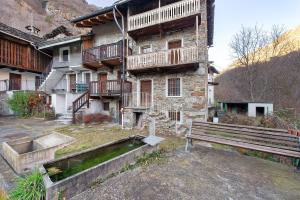 a stone building with a bench in front of it at Maison Core' in Fontainamore