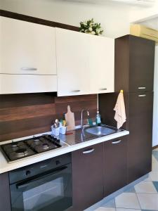 a kitchen with white cabinets and a black stove top oven at Casa Pito Pito in Alghero