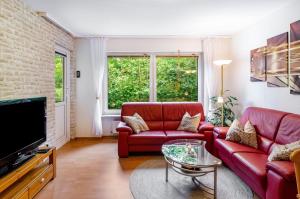 a living room with red couches and a tv at Ferienwohnung Schmälzle in Braunlage