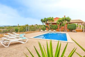 a swimming pool with lounge chairs next to a house at Sa Tanca in Pòrtol