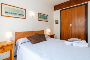 a bedroom with a bed and a wooden door at Omega 7 in L'Estartit +13 photos