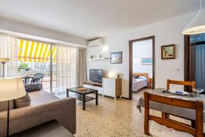 a living room with a couch and a tv at Omega 7 in L'Estartit